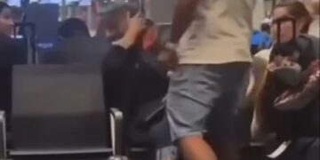 Un hombre golpeando a una mujer en una terminal del aeropuerto.