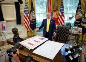 El presidente Donald Trump habla frente a los carteles que representan datos de ingresos familiares en la Oficina Oval el 7 de agosto de 2025.