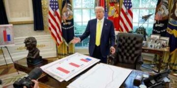 El presidente Donald Trump habla frente a los carteles que representan datos de ingresos familiares en la Oficina Oval el 7 de agosto de 2025.