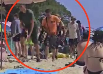 Video todavía de migrantes que llegan a una playa llena de gente.
