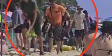Video todavía de migrantes que llegan a una playa llena de gente.