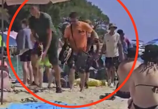 Video todavía de migrantes que llegan a una playa llena de gente.