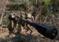 Los soldados ucranianos camufla un obús.