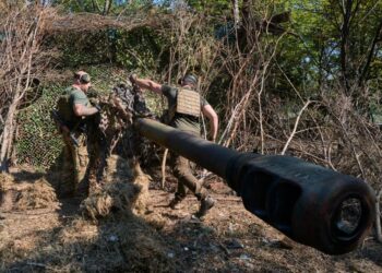 Los soldados ucranianos camufla un obús.