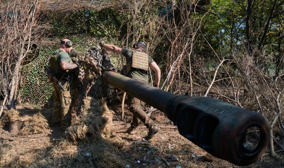 Los soldados ucranianos camufla un obús.