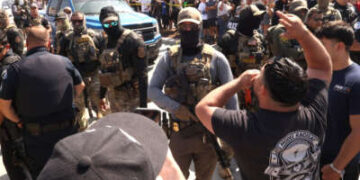 Los residentes se enfrentan a los agentes de la Patrulla Federal y Fronteriza por una redada en su vecindario en Atlantic Blvd. en la ciudad de Bell, California, el 19 de junio de 2025.