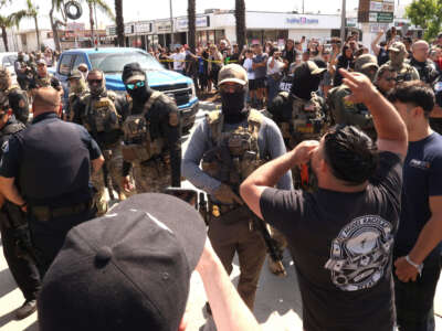 Los residentes se enfrentan a los agentes de la Patrulla Federal y Fronteriza por una redada en su vecindario en Atlantic Blvd. en la ciudad de Bell, California, el 19 de junio de 2025.