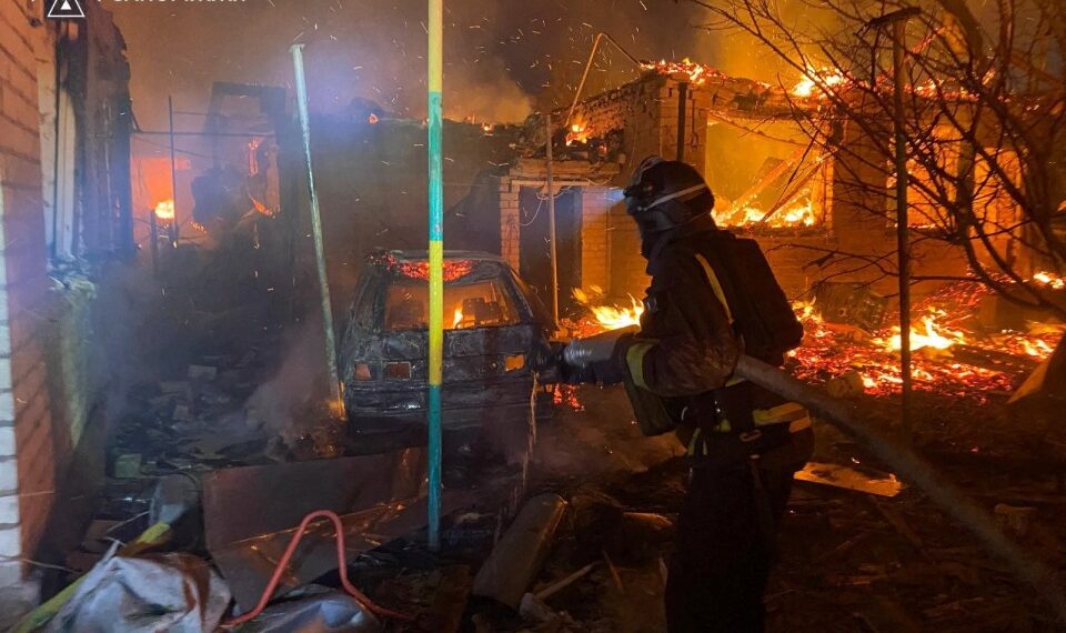Bombero luchando contra un fuego en un edificio de apartamentos dañado.
