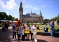 Joie Chowdhury, abogado del Centro de Derecho Ambiental Internacional; Vishal Prasad, director de estudiantes de las Islas del Pacífico que luchan contra el cambio climático; y Jule Schnakenberg, CEO de World's Youth for Climate Justice Pose con señales antes de la sesión de la Corte Internacional de Justicia encargada de emitir la primera opinión de asesoramiento sobre las obligaciones legales de los Estados de abordar el cambio climático, en La Haya, el 23 de julio de 2025.