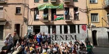 Los miembros de PAHC se sientan fuera del edificio recuperado donde Pablo y Nadia viven en Manresa, Cataluña, el 5 de mayo de 2024, para celebrar el primer aniversario de la sentadilla.