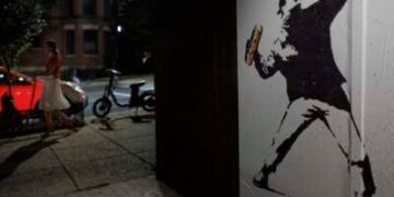 Una persona pasa por parte del trabajo de arte que representa a Sean Charles Dunn.