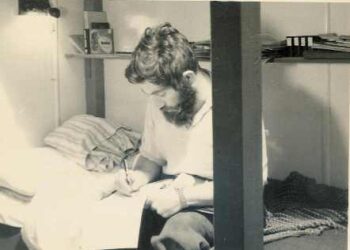 Foto en blanco y negro de Dennis Bell escribiendo.