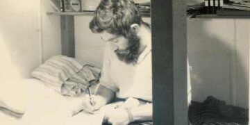 Foto en blanco y negro de Dennis Bell escribiendo.