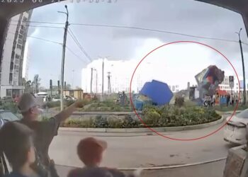 Castillo hinchable con niños adentro levantados en el aire por fuertes vientos.