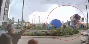 Castillo hinchable con niños adentro levantados en el aire por fuertes vientos.