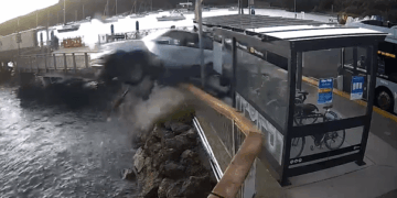 Vehículo que cae en el agua cerca de una parada de autobús.