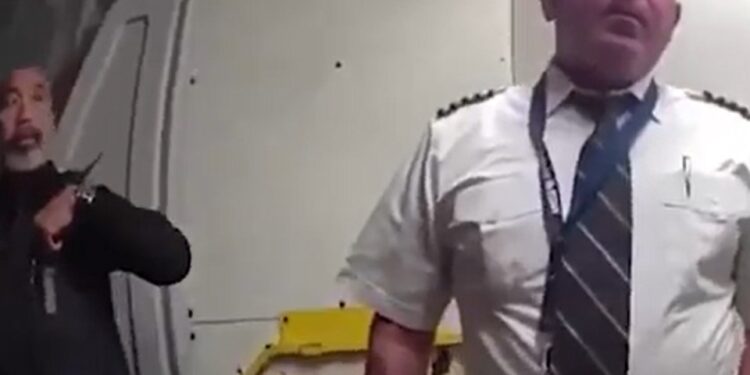 Oficial de policía escoltando a un piloto desde una cabina.