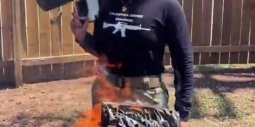 Mujer quemando un Corán con un lanzallamas.