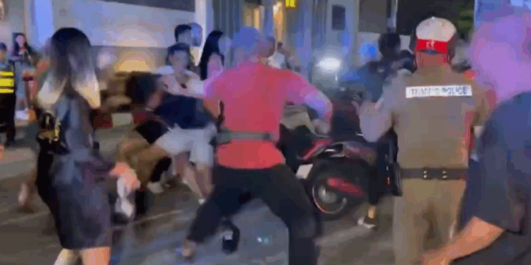 Gente que pelea en la calle con policías cercanos.