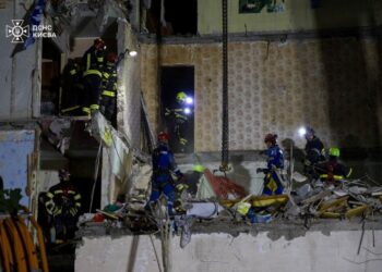 Los rescatistas que buscan sobrevivientes en un edificio de apartamentos dañados.