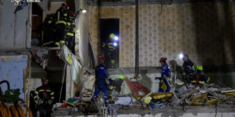 Los rescatistas que buscan sobrevivientes en un edificio de apartamentos dañados.