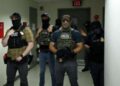 Los oficiales federales que usan revestimientos faciales esperan en un pasillo fuera de una sala del tribunal en el Tribunal Federal de Inmigración de la Plaza de Nueva York dentro del Edificio Federal Jacob K. Javitz en Nueva York.