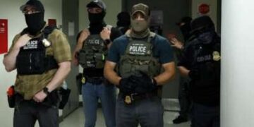 Los oficiales federales que usan revestimientos faciales esperan en un pasillo fuera de una sala del tribunal en el Tribunal Federal de Inmigración de la Plaza de Nueva York dentro del Edificio Federal Jacob K. Javitz en Nueva York.
