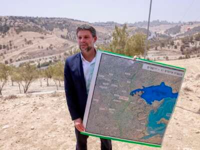 El ministro de Finanzas Israelí, Bezalel Smotrich, posee un mapa de un área cerca del asentamiento de Maale Adumim, un corredor terrestre conocido como E1, fuera de Jerusalén en la Cisjordania ocupada, el 14 de agosto de 2025, después de una conferencia de prensa en el sitio.