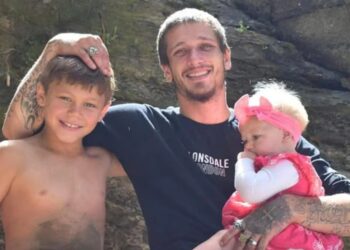 Foto de un padre con sus dos hijos pequeños.