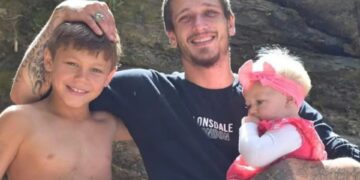 Foto de un padre con sus dos hijos pequeños.