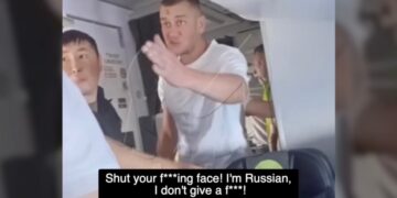 Un hombre en un avión gritando a otro pasajero.