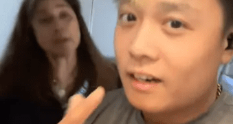 Persona que habla con la cámara, diciendo "No me pones tus manos" con otra persona en el fondo.