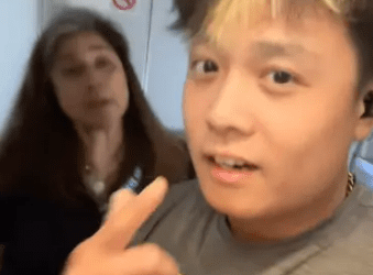 Persona que habla con la cámara, diciendo "No me pones tus manos" con otra persona en el fondo.