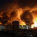 Gran fuego detrás de los edificios de la ciudad por la noche.