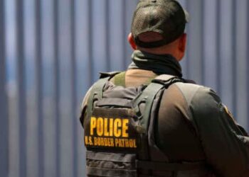 Un agente de la Patrulla Fronteriza se encuentra en el Parque Estatal Border Field con el muro fronterizo estadounidense-México en el fondo el 17 de agosto de 2025.