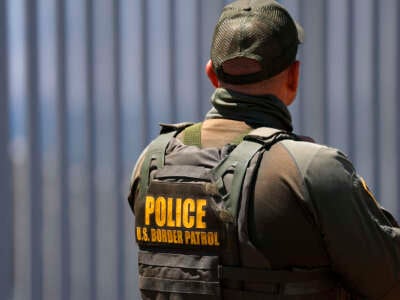 Un agente de la Patrulla Fronteriza se encuentra en el Parque Estatal Border Field con el muro fronterizo estadounidense-México en el fondo el 17 de agosto de 2025.