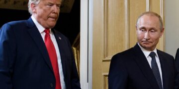 Los trabajadores de emergencia en medio de los escombros de un edificio bombardeado.