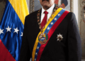 Nicolás Maduro con ropa formal con bandera venezolana.