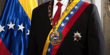 Nicolás Maduro con ropa formal con bandera venezolana.