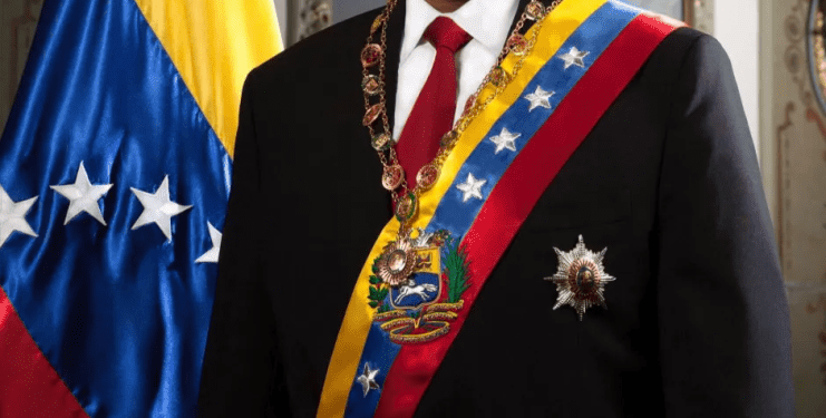 Nicolás Maduro con ropa formal con bandera venezolana.