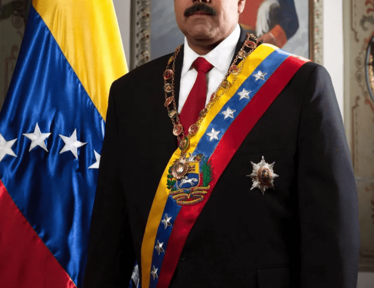 Nicolás Maduro con ropa formal con bandera venezolana.