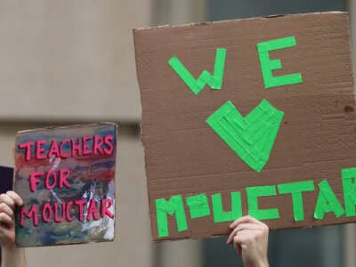 La gente tiene señales mientras los funcionarios de la ciudad de Nueva York hablan en una conferencia de prensa que convoca el lanzamiento del estudiante de secundaria Mamadou Mouctar Diallo el 14 de agosto de 2025 en la ciudad de Nueva York.