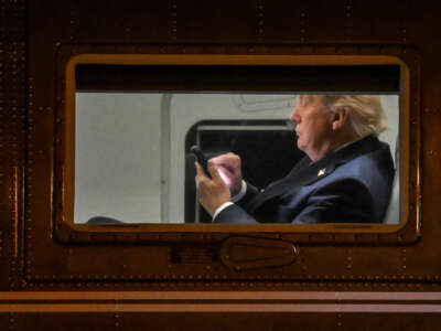El presidente Donald Trump usa un teléfono celular a bordo de Marine uno antes de que salga del aeropuerto ejecutivo de Leesburg en Leesburg, Virginia, el 24 de abril de 2025.