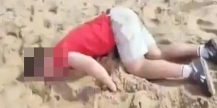 Turista drogado acostado en una playa.