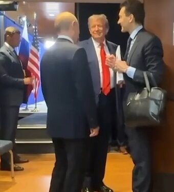 Putin y Trump hablando con otros en un pasillo.