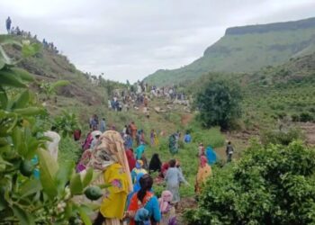 Gran grupo de personas se reunieron en un área montañosa, posiblemente respondiendo a un desastre.