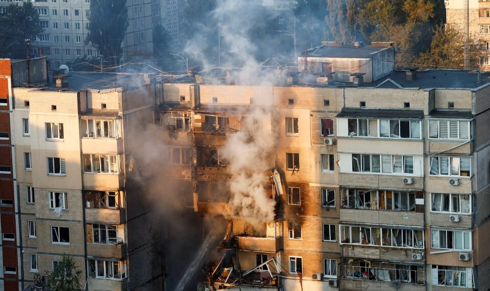 Los bomberos extinguiendo un incendio en un edificio de apartamentos dañados.