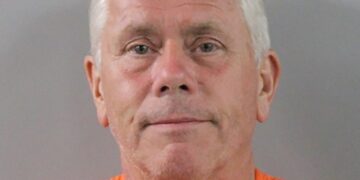 Mugshot de un hombre con un mono naranja.