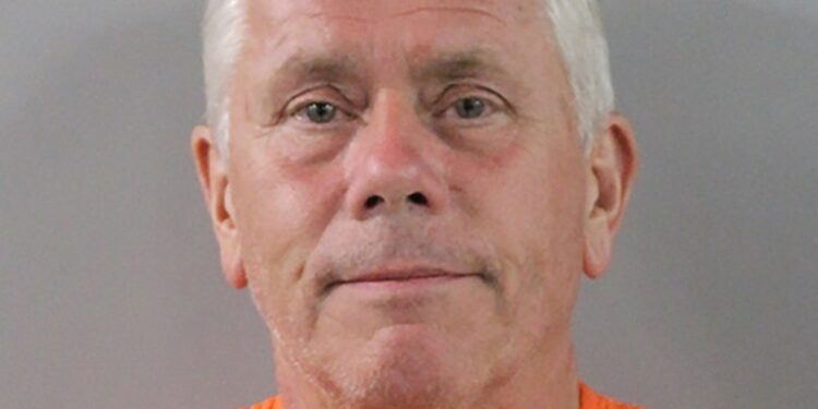 Mugshot de un hombre con un mono naranja.