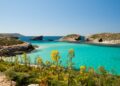 Una vista de las brillantes aguas turquesas de la laguna azul en Comino, Malta. El islote de Cominotto está a la derecha.